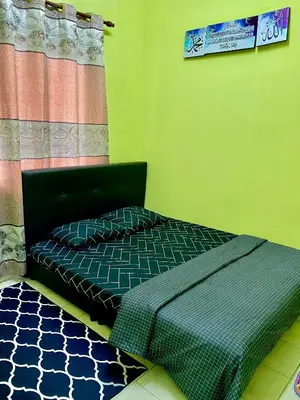 a bedroom with a bed in a room with green walls at AISY HOMESTAY - Rumah 4 atau 5 in Kampong Tanjong Karang