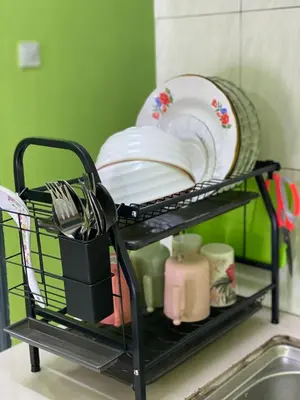 a dish drying rack with plates and dishes on it at AISY HOMESTAY - Rumah 4 atau 5 in Kampong Tanjong Karang