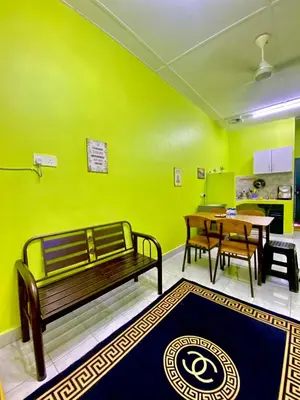 a green room with a bench and a table and a tableablish at AISY HOMESTAY - Rumah 4 atau 5 in Kampong Tanjong Karang
