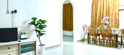 a living room with a table and a dining room at Homestay D'Art Container in Balik Pulau