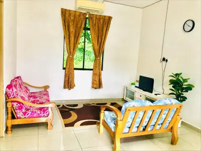 a living room with two chairs and a window at Homestay D'Art Container in Balik Pulau