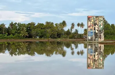 a reflection of a building in a body of water at Homestay D'Art Container in Balik Pulau