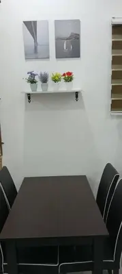 a table with chairs and plants on a wall at D'NAS HOMESTAY - Muslm Only in Sungai Besar
