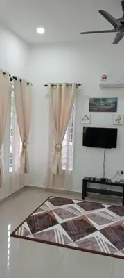 a living room with a ceiling fan and curtains at D'NAS HOMESTAY - Muslm Only in Sungai Besar