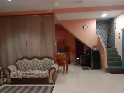 a living room with a couch and a staircase at Sobey Laris Homestay CHIKU1 in Gua Musang