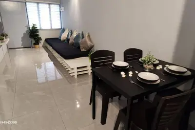 a dining room with a black table and chairs and a couch at Margosa Botani Ipoh Homestay 3BR by Grab A Stay in Ipoh
