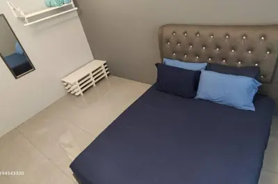 a bedroom with a large bed with blue pillows at Margosa Botani Ipoh Homestay 3BR by Grab A Stay in Ipoh