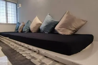 a couch with pillows on it in a room at Margosa Botani Ipoh Homestay 3BR by Grab A Stay in Ipoh
