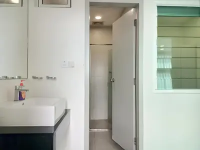 a bathroom with a white sink and a mirror at Deluxe Suites Stay, Netflix,2BR, in George Town