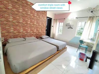a bedroom with a large bed with a brick wall at MUSANG ONG HOTEL in Cameron Highlands