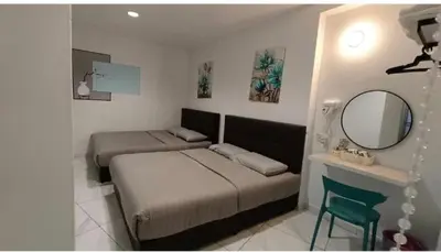 a bedroom with two beds and a mirror and a chair at MUSANG ONG HOTEL in Cameron Highlands