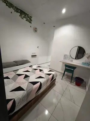 a bedroom with a bed and a mirror and a table at MUSANG ONG HOTEL in Cameron Highlands