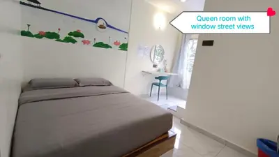a bedroom with a bed with a window and a table at MUSANG ONG HOTEL in Cameron Highlands