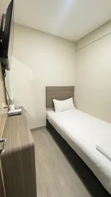 a bedroom with a bed and a flat screen tv at E Hotel Kulim in Kulim