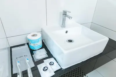 a bathroom with a sink and toiletries on a counter at E Hotel Kulim in Kulim