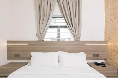 a bedroom with a large bed with a large window at E Hotel Kulim in Kulim