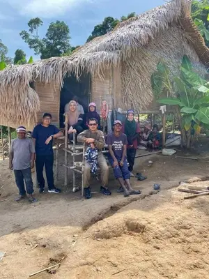 a group of people standing in front of a hut at Royal Belum Mystical in Gerik