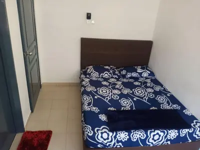 a bed with a blue and white comforter in a room at Pangkor L29, Dream Island Homestay in Kampong Sungai Udang