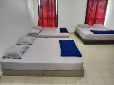two beds in a room with red curtains at Pangkor L29, Dream Island Homestay in Kampong Sungai Udang