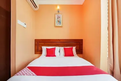 a bedroom with a bed with red pillows at Bercam Times Inn Hotel in Ipoh