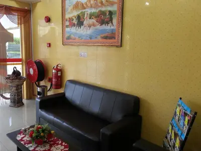 a black leather couch in a room with a painting at Bercam Times Inn Hotel in Ipoh