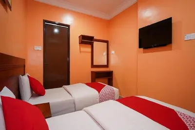 a hotel room with two beds and a flat screen tv at Bercam Times Inn Hotel in Ipoh