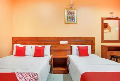 two beds in a room with red and white pillows at Bercam Times Inn Hotel in Ipoh