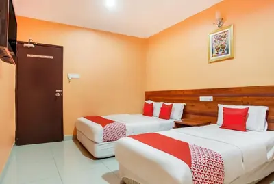 a hotel room with two beds with red accents at Bercam Times Inn Hotel in Ipoh