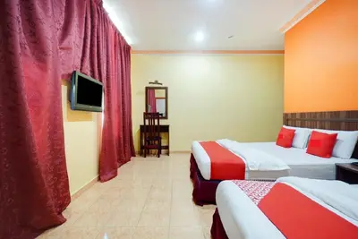 a hotel room with two beds and a tv at Hill Times Inn Hotel in Ipoh