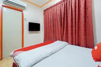 a bedroom with a bed and a red curtain at Hill Times Inn Hotel in Ipoh