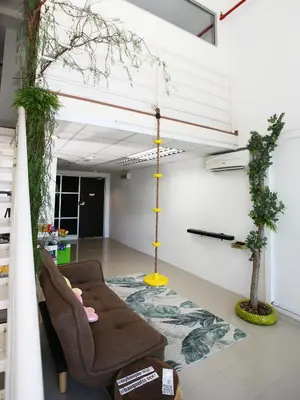 a living room with a couch and chairs on a floor at Private Tree House - Cinema at CEO Bayan Lepas Penang in Bayan Lepas