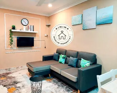 a living room with a couch and a clock on the wall at Aimima Muslim Homestay @ Lost World Of Tambun. in Kampong Batu Lapan