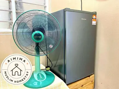 a blue fan sitting next to a computer at Aimima Muslim Homestay @ Lost World Of Tambun. in Kampong Batu Lapan