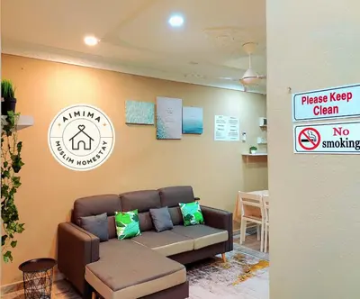a waiting room with a couch and a no smoking sign at Aimima Muslim Homestay @ Lost World Of Tambun. in Kampong Batu Lapan
