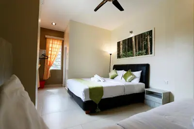 a bedroom with two beds and a painting on the wall at Golden Lodge in Tanah Rata