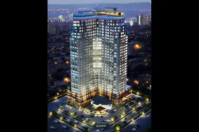 a tall building is lit up at night at Family Suites at Mansion One by MAJ in George Town