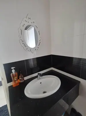 a bathroom with a white sink and a mirror at Family Suites at Mansion One by MAJ in George Town
