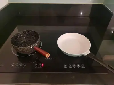 a spatula and a pan on top of a stove at Family Suites at Mansion One by MAJ in George Town