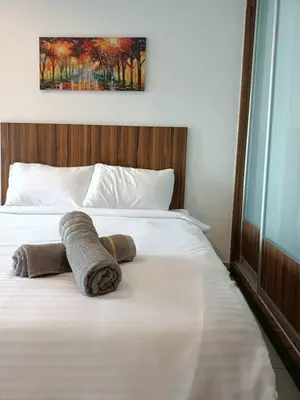 a bed with two towels on top of it at Family Suites at Mansion One by MAJ in George Town