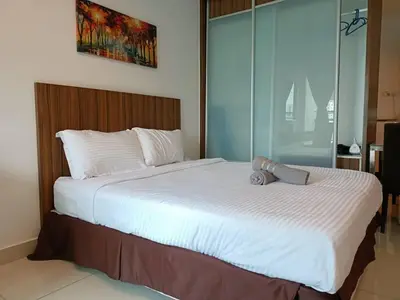 a bedroom with a large bed with white sheets at Family Suites at Mansion One by MAJ in George Town
