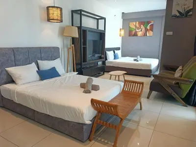 a bedroom with a bed with a teddy bear on it at Family Suites at Mansion One by MAJ in George Town