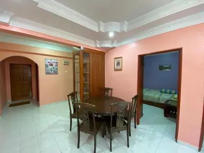 a dining room with a table and a bed at Holiday Homestay Cameron Highlands in Tanah Rata