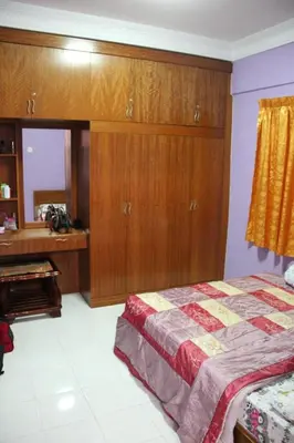 a bedroom with a bed and wooden cabinets and a piano at Holiday Homestay Cameron Highlands in Tanah Rata