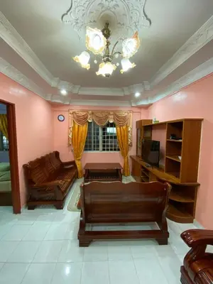 a living room with a couch and a chandelier at Holiday Homestay Cameron Highlands in Tanah Rata