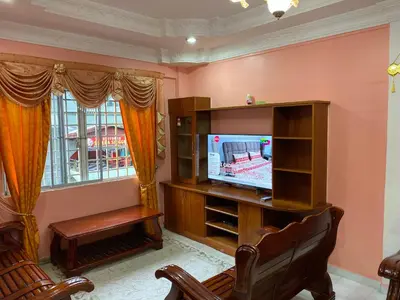 a living room with a tv and a chair at Holiday Homestay Cameron Highlands in Tanah Rata