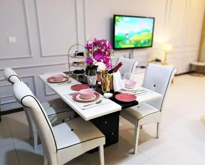 a dining room with a table with chairs and a tv at \u7687\u5bb6\u6d77\u666fROYAL Luxury Seaview Room, 3 minute to Gurney in Tanjong Tokong