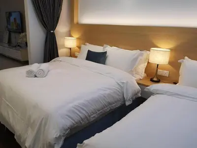 two beds in a hotel room with two lamps at \u7687\u5bb6\u6d77\u666fROYAL Luxury Seaview Room, 3 minute to Gurney in Tanjong Tokong