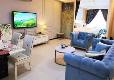 a large living room with blue furniture and a tv at \u7687\u5bb6\u6d77\u666fROYAL Luxury Seaview Room, 3 minute to Gurney in Tanjong Tokong