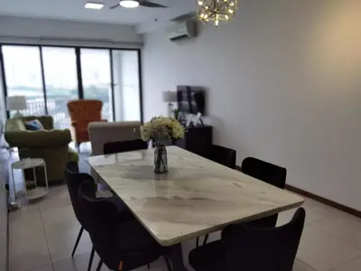 a dining room table with chairs and a vase of flowers at Tree Family Executive Suite 3 BR /8 PAX Gurney in Tanjong Tokong