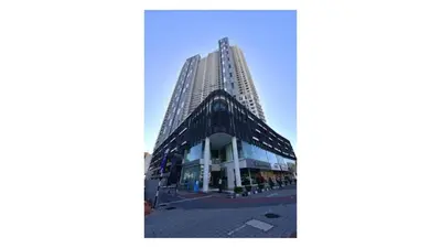a tall building in front of a blue sky at Tree Family Executive Suite 3 BR /8 PAX Gurney in Tanjong Tokong